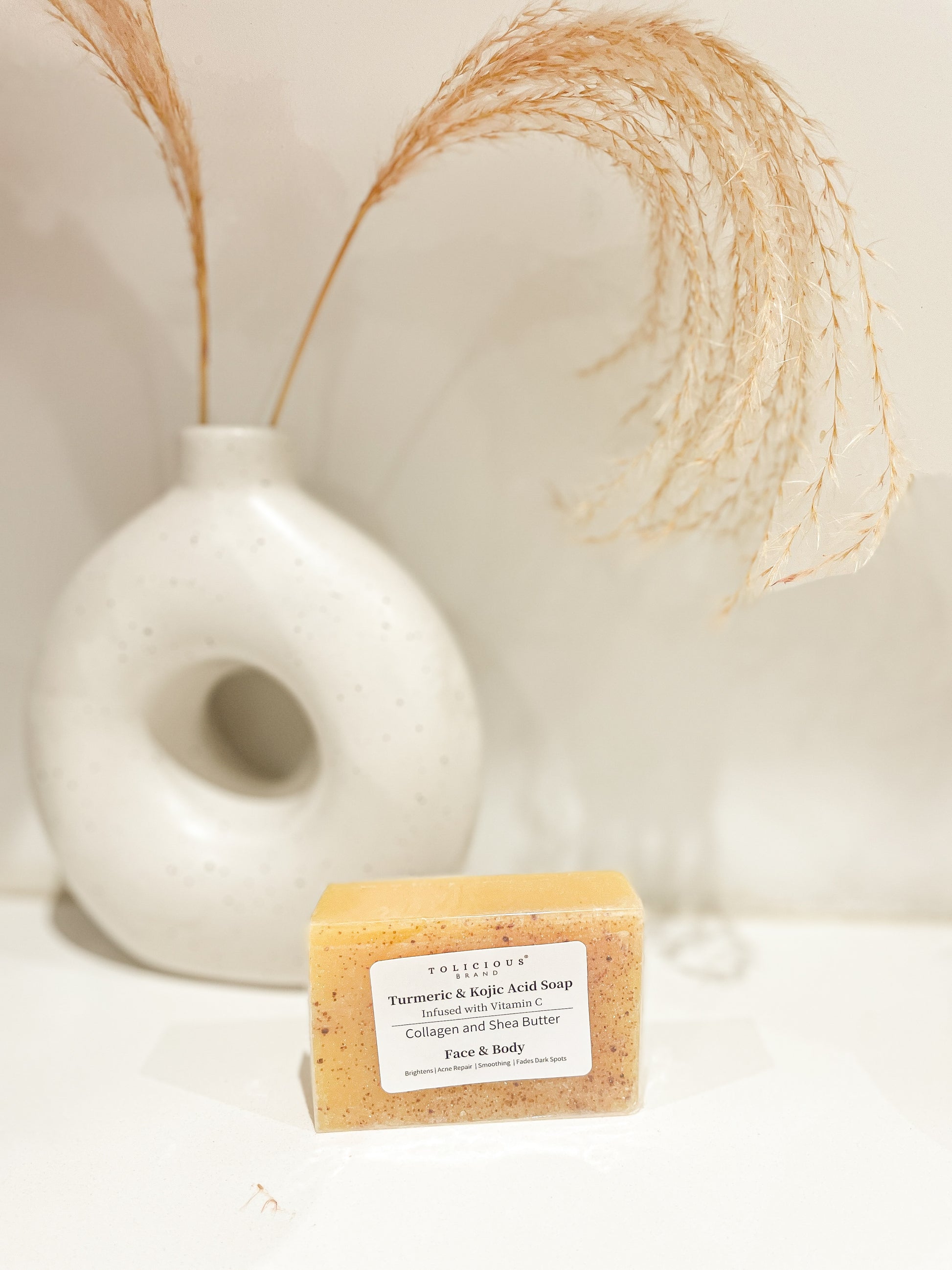 Tolicious Brand brightening soap for face and body with turmeric and kojic acid in a rectangular bar