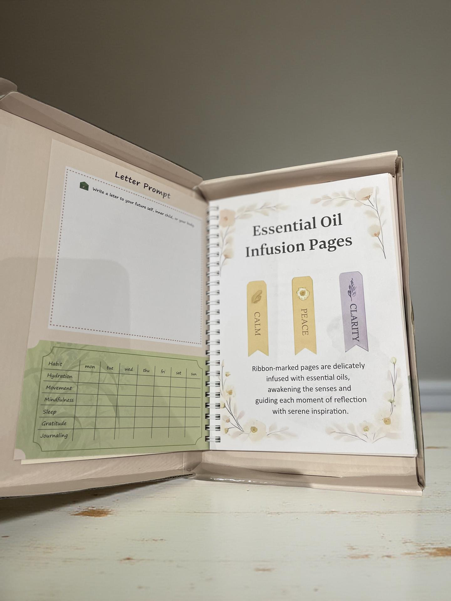 Tolicious Brand essential oil infused journal open to essential oil infusion pages with calm peace clarity tabs